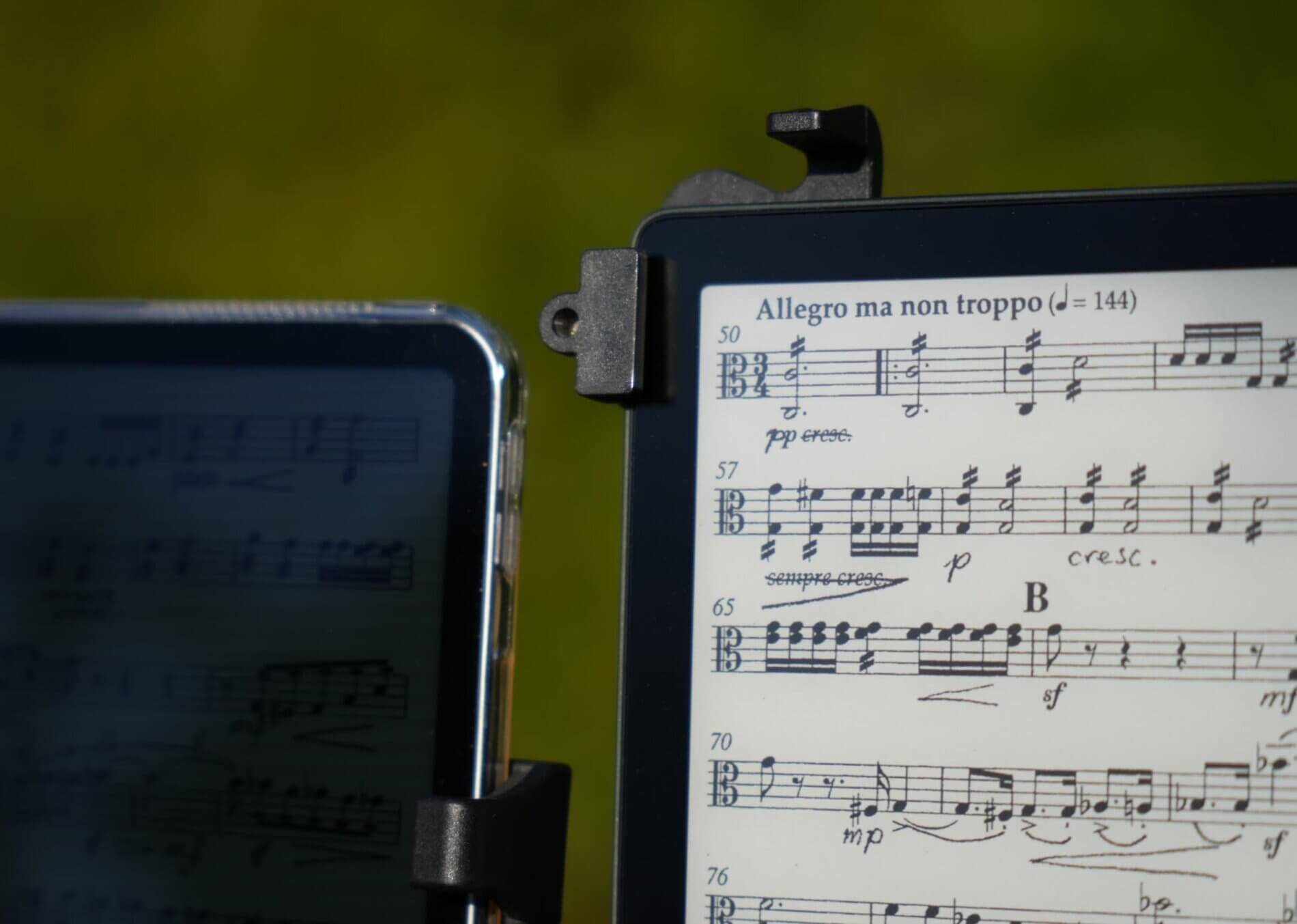 Ein E-Reader und ein Tablet (iPad) mit Musiknoten in direktem Sonnenlicht